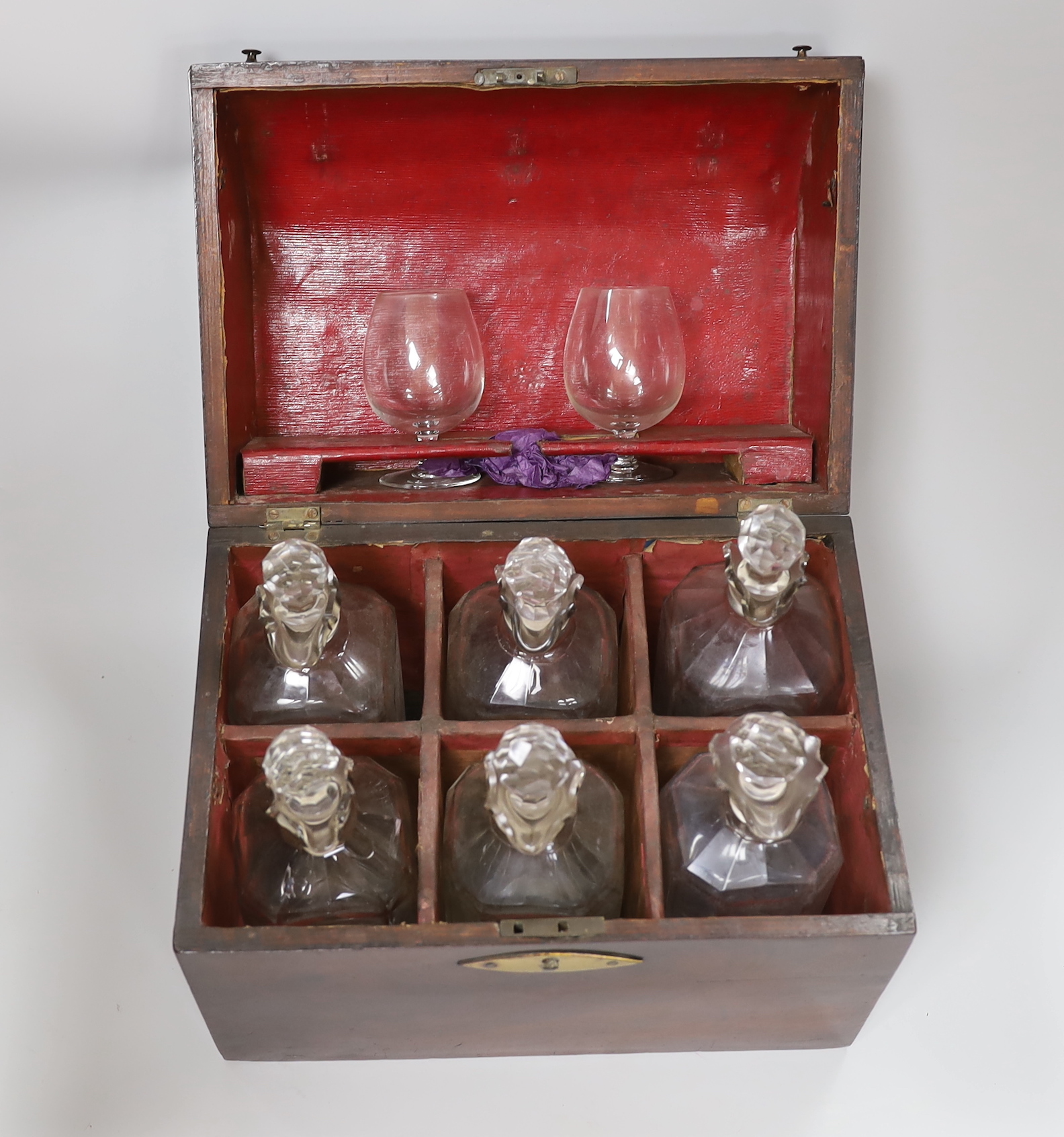 A decanter box with brass mount, possibly rosewood, six decanters and two glasses, 27cm wide